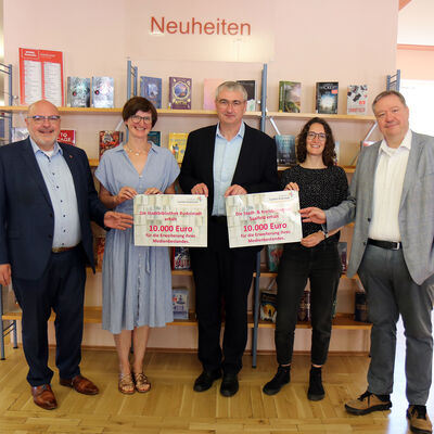 Landrat Marko Wolfram (Mitte) übergibt Bibliotheksfördermittel